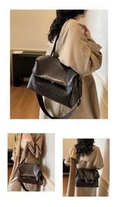 Detail of dark brown crocodile texture leather bag with detachable wide woven strap