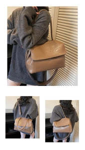 Macro detail of brown crocodile embossed texture on a large flap crossbody bag