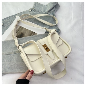 Détail d'un sac bandoulière en cuir blanc crème avec élégant fermoir rotatif doré