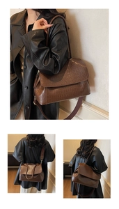 Detail of brown crocodile pattern shoulder bag with wide strap and embossed texture