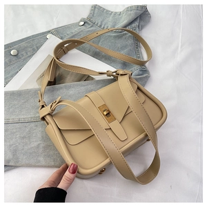 Détail du sac beige avec fermoir rotatif en métal doré et deux fines bandoulières