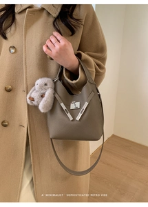 Chic taupe bucket bag with silver V-shaped metal lock and plush rabbit charm detail