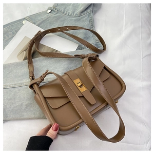 Détail d'un sac à bandoulière en cuir marron avec fermoir rotatif carré doré élégant