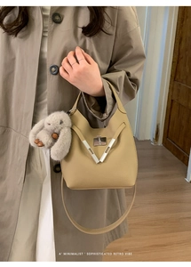 Detail of beige faux leather bucket bag with silver buckle and plush rabbit pendant