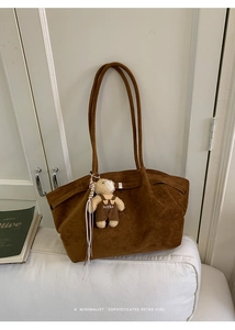Close-up of vintage brown suede tote bag featuring a cute teddy bear pendant charm