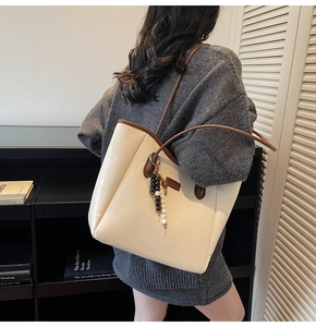 Détail du grand sac cabas vintage avec bandoulières marron et charm perlé élégant