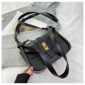 Détail du sac bandoulière en cuir noir avec un fermoir tournant doré élégant
