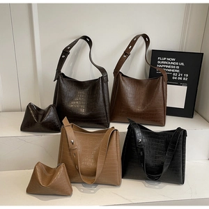 Detail of crocodile-embossed hobo bags in various colors with matching coin purses