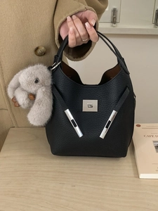 Minimalist black pebbled leather bucket bag with silver hardware and rabbit charm