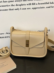 Sac bandoulière minimaliste crème avec fermoir doré et détails passepoilés