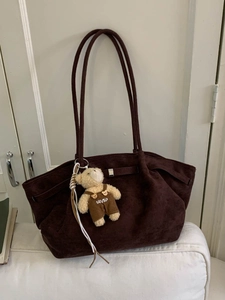 Retro chocolate brown suede tote bag with a cute plush bear pendant on a white background