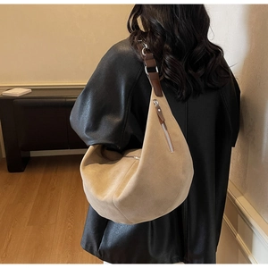 Detail of suede hobo bag showing its large capacity and apricot textured finish on the shoulder