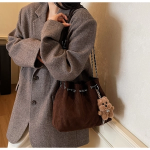 Detail of vintage brown suede bucket bag with diamond stitching and silver chain
