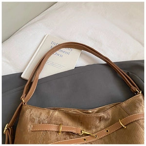 Detail of caramel velvet tote bag texture with brown leather strap and gold hardware