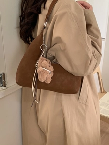 Brown faux suede crescent tote bag with a cute plush bear pendant on a shoulder strap