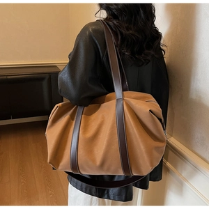 Detail of vintage oversized brown leather tote with white stitching and spacious interior