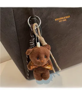 Detail of plush brown bear bag charm with woven rope and Love ribbon accessory