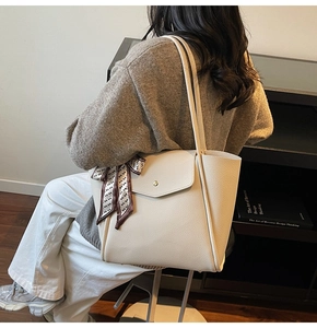 Détail grand sac cabas beige avec foulard en soie et poche avant à rabat boutonné