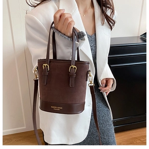 Close-up of dark brown contrast stitching bucket bag with gold hardware and logo detail
