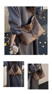 Detailed view of large brown faux leather tote bag with vintage texture and metal buckle
