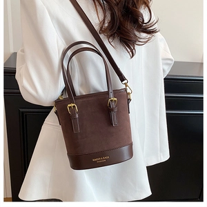 Detail view of contrast stitching and suede texture on dark brown leather bucket bag