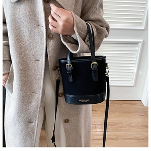Detailed view of black bucket bag with gold hardware and KMDER & BAGS logo branding
