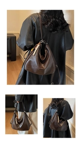 Detail view of dark brown Hobo bag with bohemian tassel charm on black leather jacket