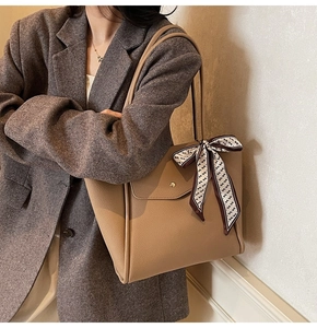 Détail du grand sac cabas en cuir kaki avec boucle dorée et foulard en soie imprimé