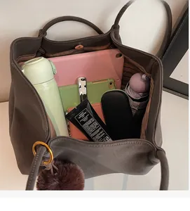 Macro shot showing large storage capacity of the dark brown tote bag with various items