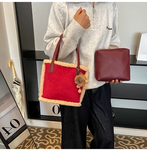 Détail du sac à main rouge en peluche avec bordure en fausse fourrure et breloque lion