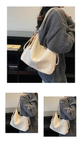Detailed side view of off-white Hobo bag with stylish beaded fringe tassels decoration