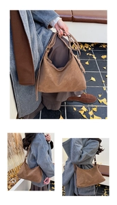 Detail view of large dark brown suede tote bag featuring sleek zipper and shoulder straps