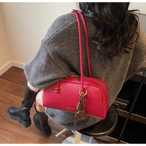 Detail of red textured leather bowling bag with metal zipper and stylish top handles