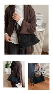 Detail of black suede tote bag with white contrast stitching and adjustable strap