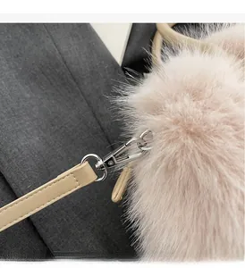 Détail du fermoir pivotant argenté et texture en fausse fourrure d'un sac à bandoulière