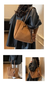 Detail of a large brown faux leather tote bag with a plush bear charm and sleek shoulder strap