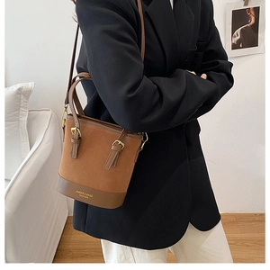 Detail of vintage brown contrast bucket bag featuring mixed leather textures and gold logo