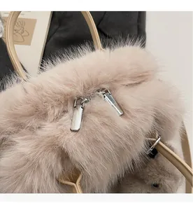 Détail du sac à main en fausse fourrure beige avec doubles fermetures éclair et anses