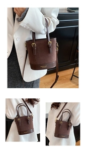 Three-way view of a dark brown colorblock bucket bag with adjustable strap and top handles