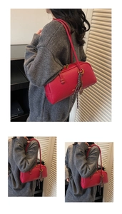 Detail of red pebbled leather pillow bag featuring elegant woven tassel and slim straps