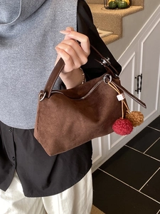 Sac à main en daim marron avec pompons en peluche pour un look décontracté