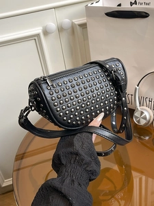 Minimalist black crescent crossbody bag with silver rivet studs and sleek zip closure