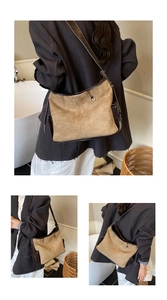 Detail view of brown matte suede shoulder bag with leather piping and slim strap