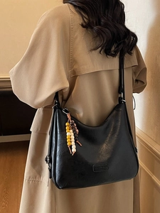 Retro black crescent shoulder bag with colorful wooden beads on model in beige trench coat