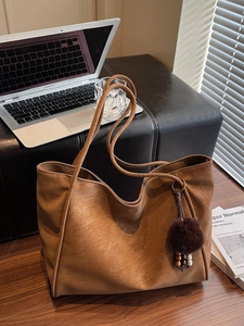 Grande borsa tote in ecopelle marrone scuro con ciondolo pompon su panca
