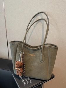 Deep green faux suede large tote bag with bear charm on minimalist black books