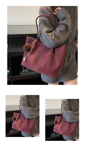 Detail of burgundy tote bag with brown pom-pom charm and vintage matte leather finish