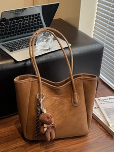 Large brown leather tote bag with leopard lining and cute bear charm for daily commute