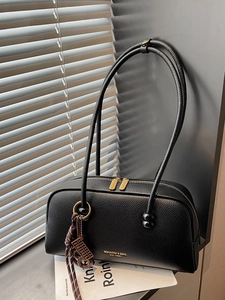 Retro black pebbled leather bowling bag with gold hardware and woven charm detail