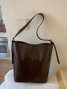 Sac seau minimaliste en similicuir marron foncé avec bandoulière réglable pour le bureau